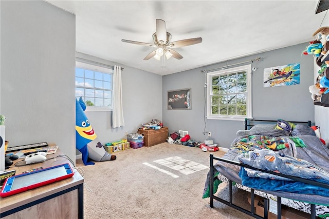 carpeted bedroom featuring multiple windows and ceiling fan