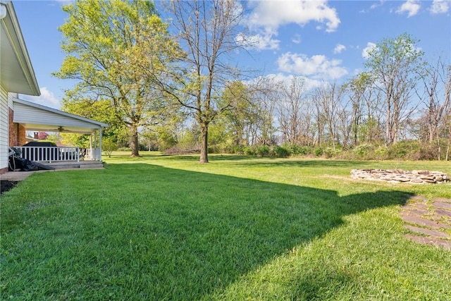 view of green lawn featuring covered porch