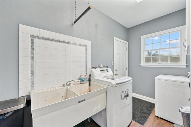 laundry room with separate washer and dryer, light wood-style flooring, and baseboards