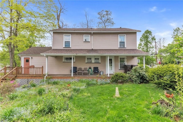 rear view of property with a lawn and a deck