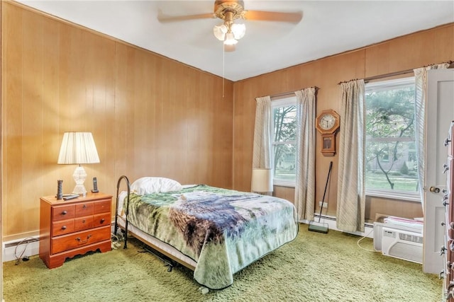 carpeted bedroom featuring a ceiling fan and wood walls
