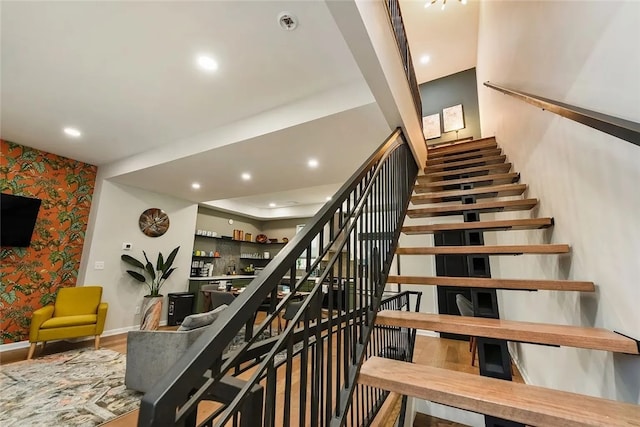 stairs with wallpapered walls, baseboards, recessed lighting, and wood finished floors
