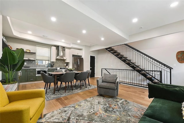 living area featuring light wood-style flooring, stairway, and recessed lighting