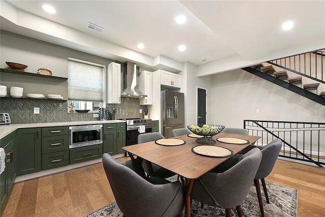dining area featuring stairway, light wood finished floors, and recessed lighting
