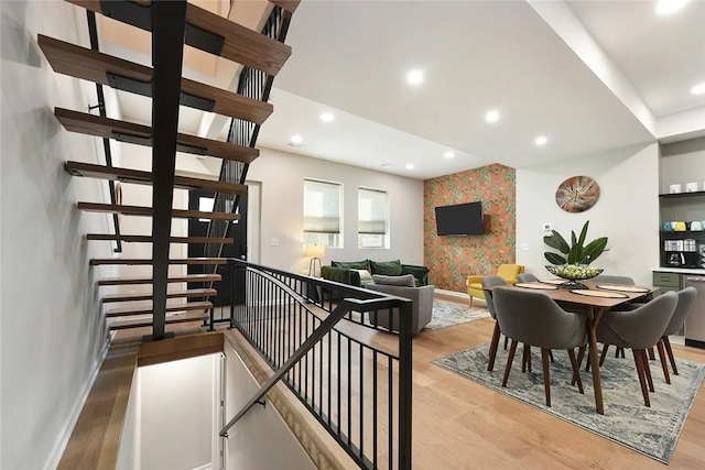 dining room featuring an accent wall, light wood-style flooring, baseboards, recessed lighting, and wallpapered walls