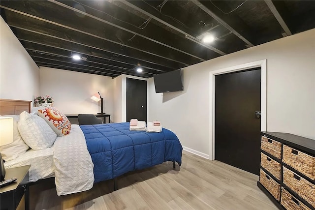 bedroom with light wood finished floors and baseboards