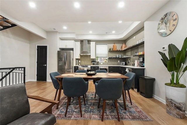 dining space with light wood finished floors, baseboards, and recessed lighting