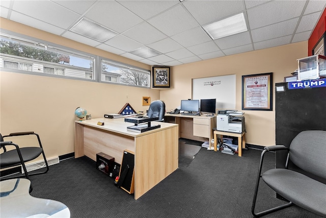 office space with dark colored carpet, a paneled ceiling, and baseboards