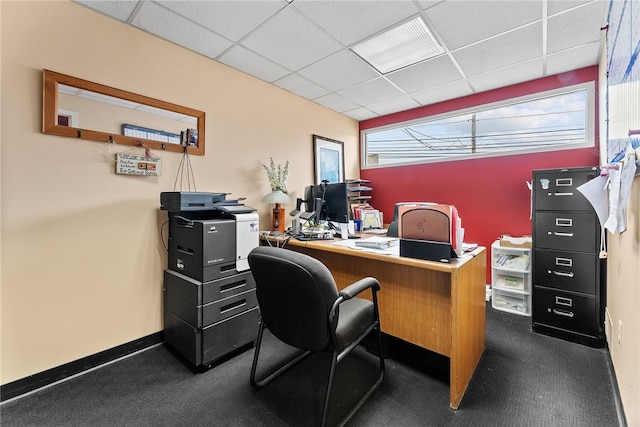office area featuring a paneled ceiling, baseboards, and dark colored carpet