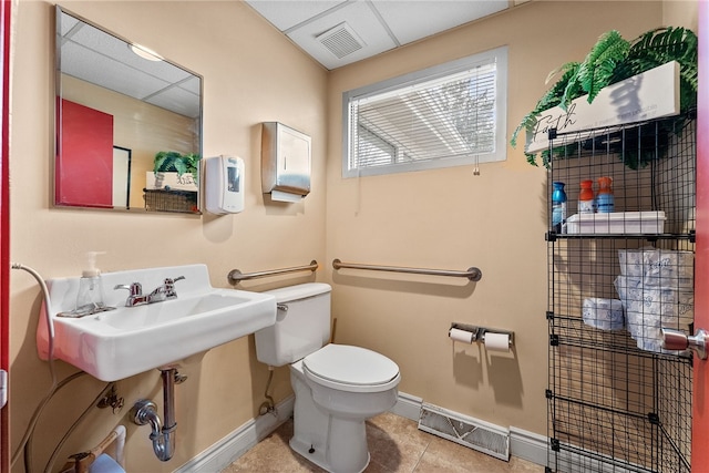 bathroom featuring baseboards, toilet, and tile patterned flooring