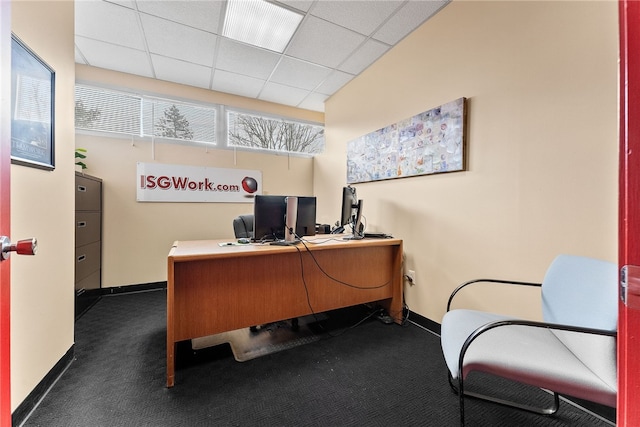 home office with baseboards, dark colored carpet, and a paneled ceiling