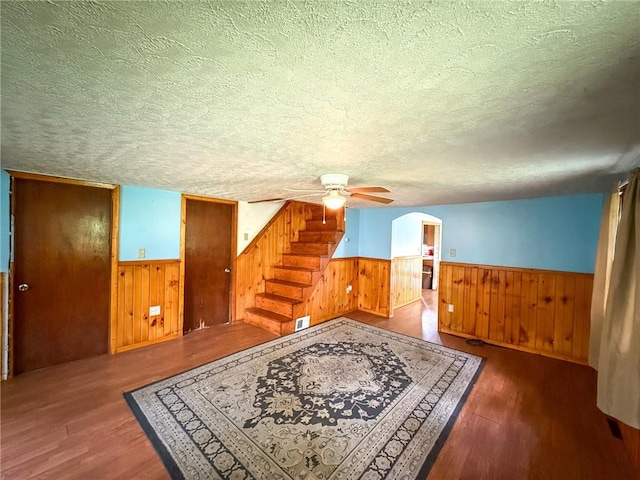 155 Elm St, Saint Clair Twp, PA 15954 - unfurnished living room with a wainscoted wall, a textured ceiling, a ceiling fan, arched walkways, and wood finished floors