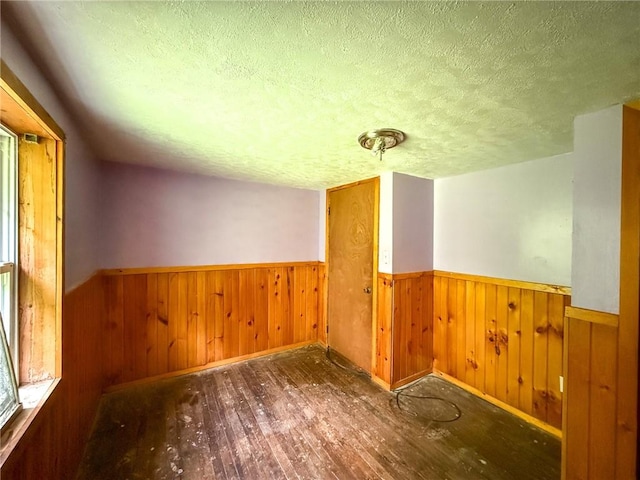 155 Elm St, Saint Clair Twp, PA 15954 - unfurnished room with a textured ceiling, wainscoting, wood-type flooring, wood walls, and baseboards