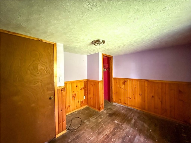 155 Elm St, Saint Clair Twp, PA 15954 - spare room with a wainscoted wall, a textured ceiling, wood finished floors, baseboards, and wood walls