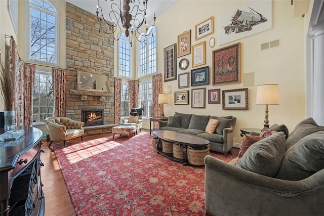904 Champlain Pl, Adams Twp, PA 15044 - living room with a high ceiling, plenty of natural light, a chandelier, wood finished floors, and a stone fireplace
