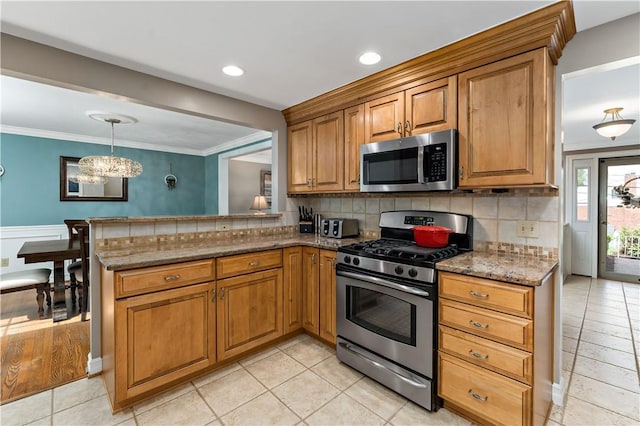 kitchen featuring stainless steel appliances, stone countertops, ornamental molding, brown cabinets, and decorative backsplash
