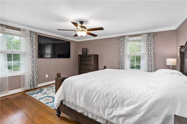 bedroom featuring baseboards, wood finished floors, ornamental molding, and ceiling fan