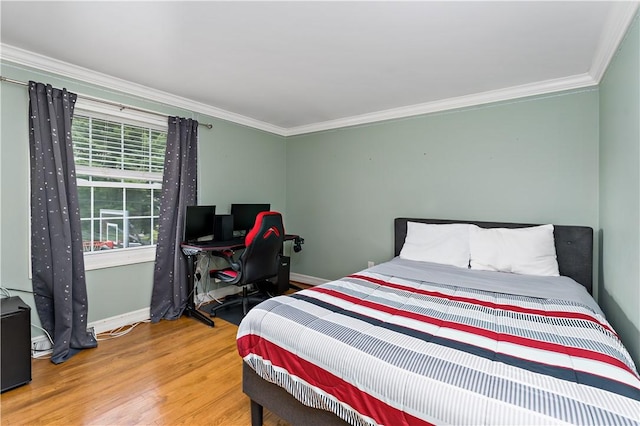 bedroom featuring ornamental molding, baseboards, and wood finished floors