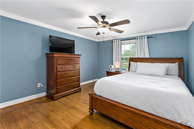 bedroom featuring ornamental molding, baseboards, wood finished floors, and ceiling fan