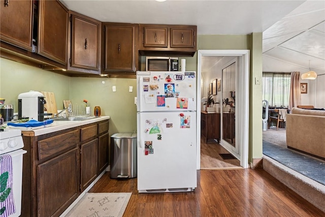 kitchen with freestanding refrigerator, dark wood-style flooring, range, light countertops, and a sink
