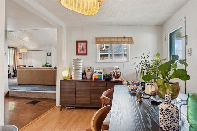 dining room featuring wood finished floors and a textured ceiling