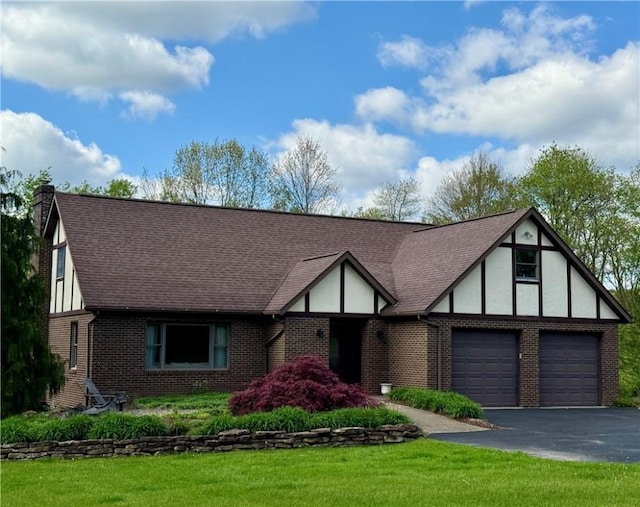 111 Mccall Rd, Franklin Twp But, PA 16001 - tudor home with brick siding, driveway, a chimney, a front yard, and roof with shingles