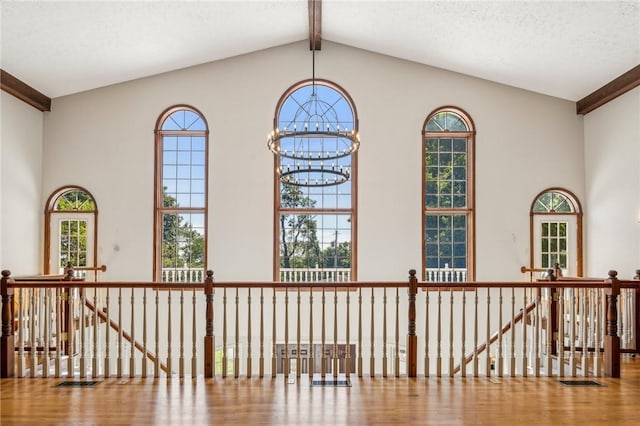 detailed view of wood finished floors, a chandelier, and beamed ceiling