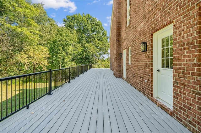 wooden deck featuring a lawn