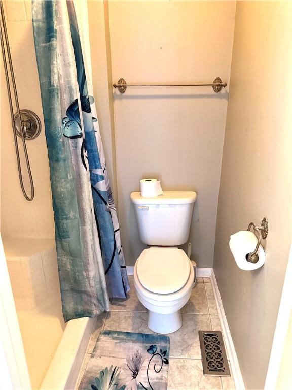 491 Peregrine Dr, North Huntingdon, PA 15642 - full bathroom featuring a stall shower, tile patterned flooring, toilet, and baseboards