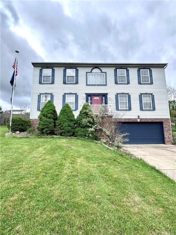 491 Peregrine Dr, North Huntingdon, PA 15642 - colonial-style house with concrete driveway, a garage, a front yard, and brick siding