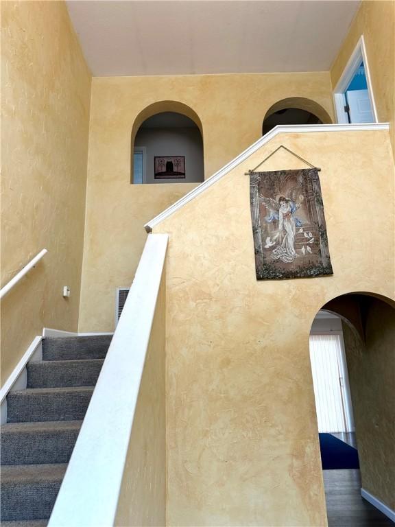 491 Peregrine Dr, North Huntingdon, PA 15642 - staircase with arched walkways and a textured wall