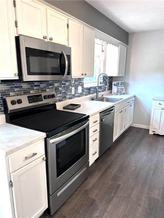 491 Peregrine Dr, North Huntingdon, PA 15642 - kitchen with appliances with stainless steel finishes, a sink, tasteful backsplash, and dark wood-type flooring