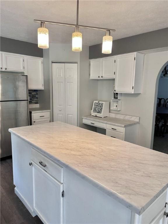 491 Peregrine Dr, North Huntingdon, PA 15642 - kitchen with freestanding refrigerator, arched walkways, white cabinetry, and dark wood-style flooring
