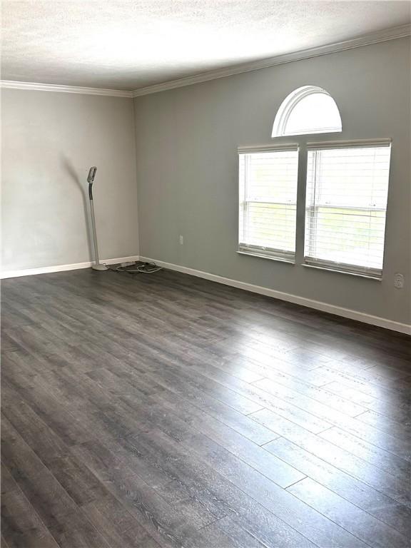 491 Peregrine Dr, North Huntingdon, PA 15642 - empty room with crown molding, dark wood-style floors, baseboards, and a textured ceiling