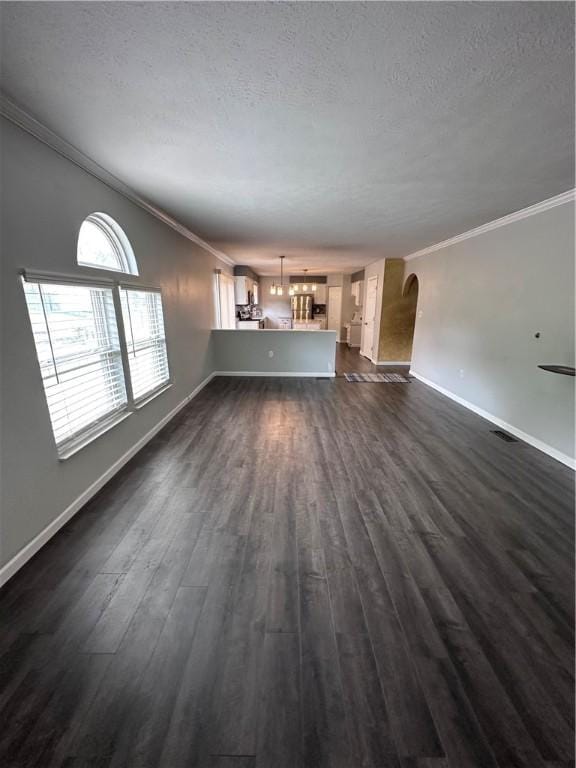 491 Peregrine Dr, North Huntingdon, PA 15642 - unfurnished living room with arched walkways, ornamental molding, a textured ceiling, dark wood-type flooring, and baseboards