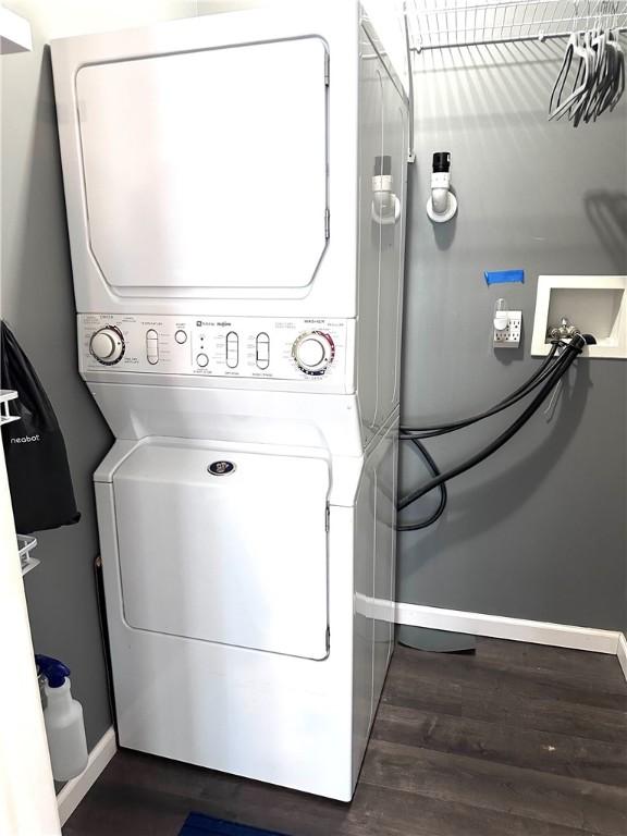 491 Peregrine Dr, North Huntingdon, PA 15642 - clothes washing area with stacked washer and clothes dryer, baseboards, and dark wood-style flooring