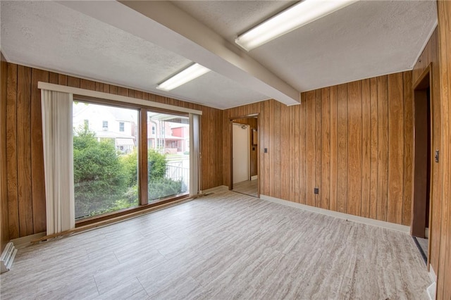 710 4th Ave, Ford City Boro, PA 16226 - unfurnished room with a textured ceiling, wooden walls, beam ceiling, light wood-type flooring, and baseboards