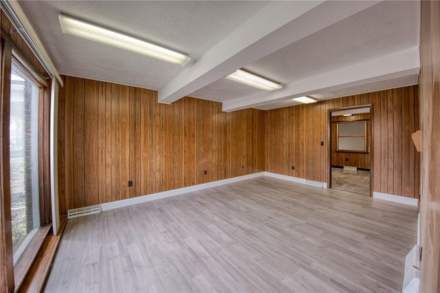 710 4th Ave, Ford City Boro, PA 16226 - unfurnished room with beamed ceiling, light wood-type flooring, wood walls, plenty of natural light, and baseboards