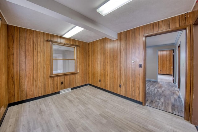 710 4th Ave, Ford City Boro, PA 16226 - spare room featuring light wood-style flooring, wooden walls, beam ceiling, and baseboards