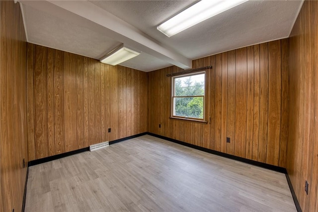 710 4th Ave, Ford City Boro, PA 16226 - unfurnished room with light wood-style floors, wood walls, a textured ceiling, and beamed ceiling