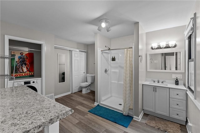 2611 Jane St, South Side, PA 15203 - full bath featuring a stall shower, wood finished floors, toilet, vanity, and washer / dryer