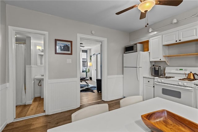 2611 Jane St, South Side, PA 15203 - kitchen with white appliances, dark wood finished floors, a wainscoted wall, a ceiling fan, and light countertops