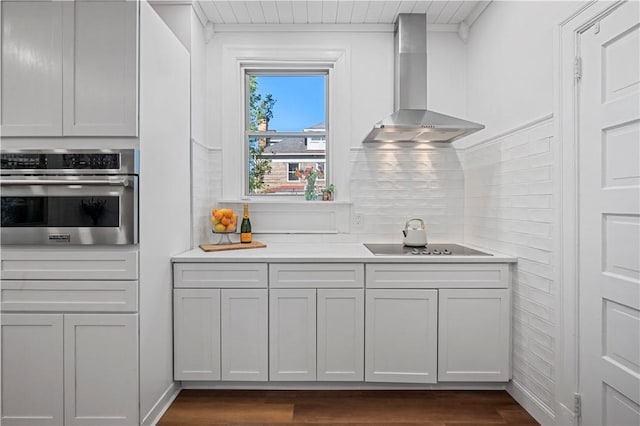 209 Bon Air Ave, Bon Air, PA 15210 - kitchen featuring stainless steel oven, wall chimney range hood, dark wood-type flooring, light countertops, and black electric cooktop