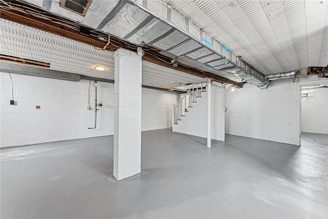 basement featuring stairs and concrete block wall