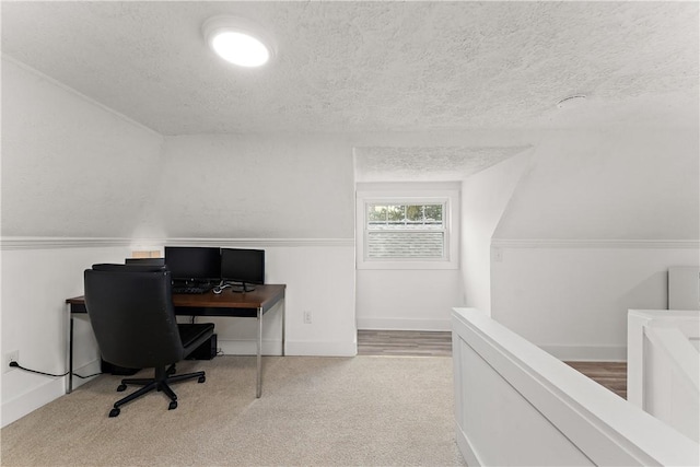 carpeted home office featuring a textured ceiling