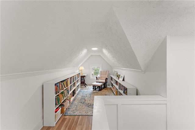 office area with lofted ceiling, a textured ceiling, wood finished floors, and baseboards