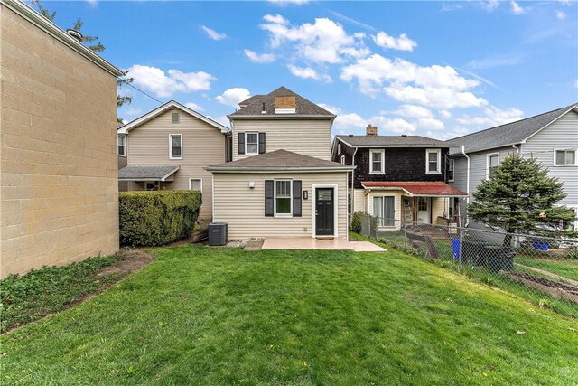 rear view of property with a patio area, central air condition unit, and a chimney