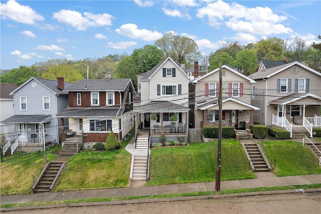 multi unit property with stairs, a residential view, and a front lawn