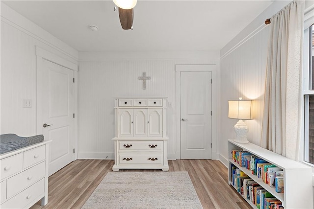 playroom featuring light wood-style flooring, ceiling fan, and baseboards