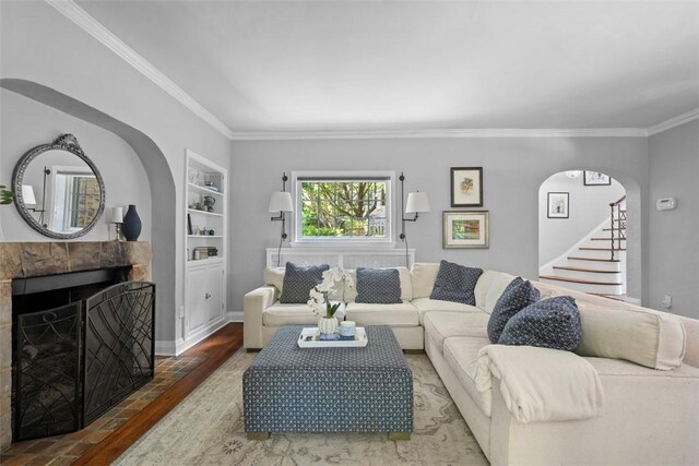 401 Parker Dr, Mt Lebanon, PA 15216 - living room featuring wood finished floors, ornamental molding, arched walkways, a tiled fireplace, and stairway